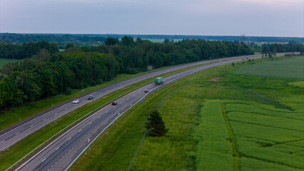 Cars movement on a highway, aerial view. Car traffic on a suburban highway in summer day. Logistic and travel concept. Lithuania