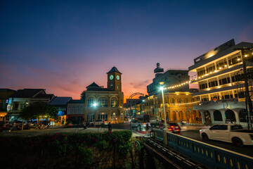 Fototapeta premium Tourists like to take photos at the clock tower, an old building in Phuket city. beautiful sky in twilight.popular landmark in Phuket. a beautiful old building in the heart of Phuket Town.