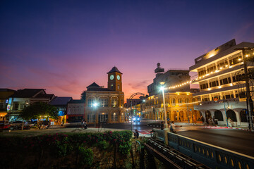 Tourists admire the clock tower, a beautiful old building at Charter Intersection in the heart of Phuket Town..clock tower the ancient building and popular landmark in Phuket city