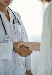 doctor and patient shake hands in the hospital after finishing treatment. health care concept