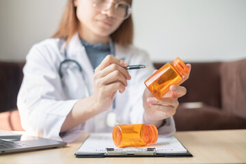 Female doctor holding a medicine bottle is checking the quality of medicine for any side effects...