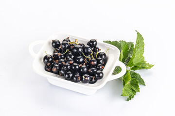 Juicy black currant berries in the bowl