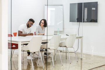 Two Colleagues Collaborate in Modern Office Conference Room