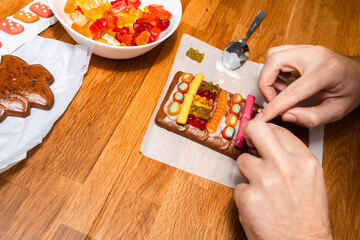 Design of gingerbread cookies house, men hands