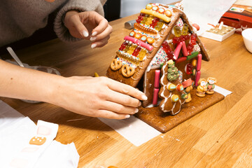 Hands designing gingerbread cookies house. Christmas concept