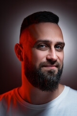 Fototapeta premium Studio portrait with colorful light of young handsome bearded man.