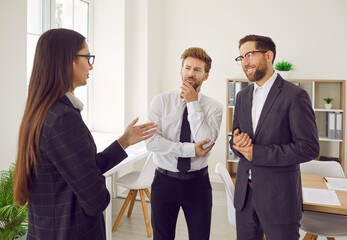 Obraz premium Group of business people chatting on a meeting. Company employees talking in the office and making great decisions with brainstorming. Cowokers listen to their colleague at the working place.