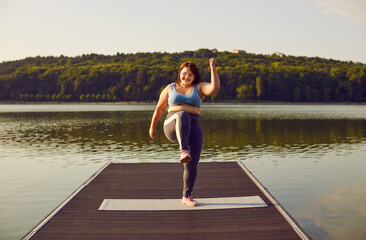Woman having outdoor summer workout in nature. Happy cheerful fat plus size girl in fitness...