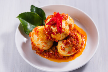 Telur bumbu balado or spicy boiled egg in a white plate. with copy space. Perfect for recipe, article, or any cooking contents.