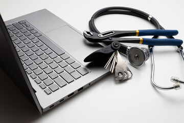 Spanner and stethoscope on laptop, closeup. Concept of technical support