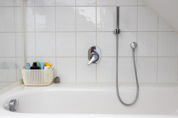 Bathtub with the woven basket for shampoo and hair care products
