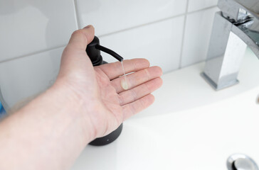 A hand operated soap dispenser in the bathroom