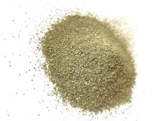 Dried pile of lovage leaves on a white background.