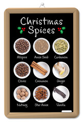 Blackboard with Christmas spices and scents of winter holidays in white bowls, with English labeling. Allspice, anise seed, cardamom, cloves, cinnamon, fresh ginger, nutmeg, star anise and vanilla.