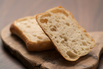 sliced ciabatta bun on wood board closeup