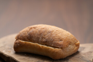 sliced ciabatta bun on wood board closeup
