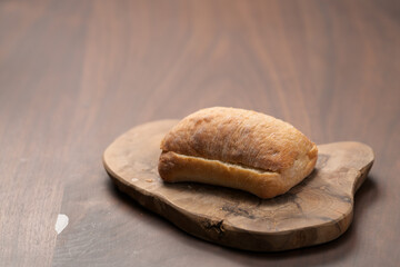 sliced ciabatta bun on wood board closeup