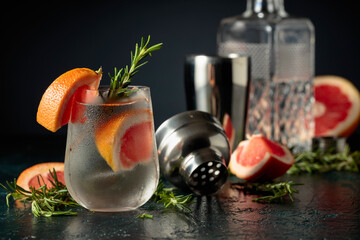 Cocktail gin tonic with ice, grapefruit, and rosemary.
