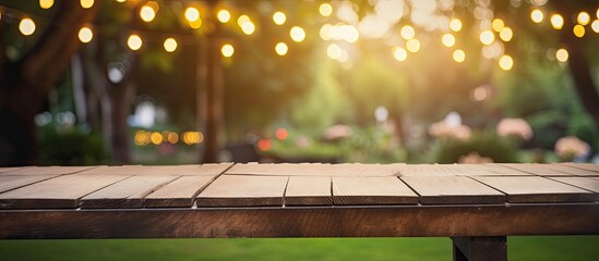 Empty wooden table and bulbs within party in garden background blurred. Creative banner. Copyspace image