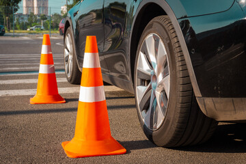 Plastic signaling traffic cones in the parking car during driving test outdoors. Cropped. Driving...