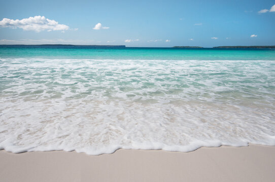 Idyllic water and small waves on white sandy beach