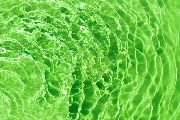 Watery waves with shining swirl texture on a vibrant green background. Abstract background idea....