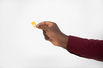 black Hand holding yellow SIM card over white background
