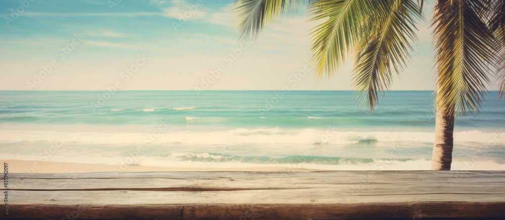 Poster blur tropical beach with bokeh sun light wave and palm tree on copy space empty old wood table abstr