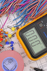 Digital multimeter and insulated copper mounting wires. Close-up. Soft focus.