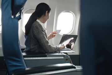 Businesswoman making online purchase during flight, Concept of work-life balance