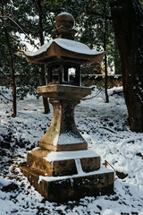 Ancient style traditional Japanese lantern covered in rare winter snow at Fushimi Inari Shrine