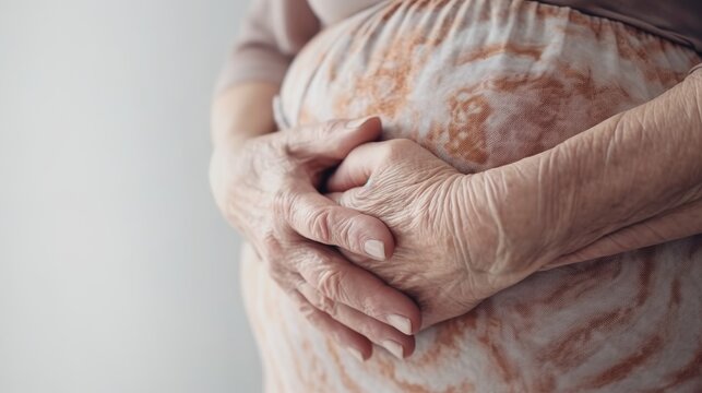 Elderly woman holding her stomach close-up