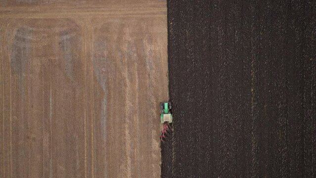 Aerial view of a tractor plowing field for sowing. Farm tractor with rotary harrow preparing land
