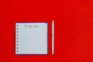 To do list on the red table with pen. Planning and organization of work. Plat lay place for text