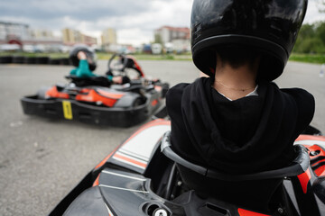 Go-Kart Racing Action With Focused Driver In Black Helmet