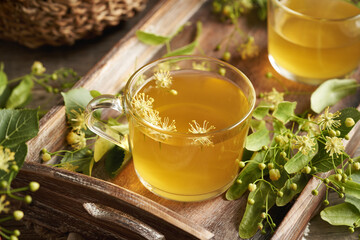 A cup of herbal tea with fresh linden or Tilia cordata flowers collected in spring