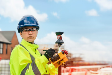 Professional woman builder surveyor site engineer with surveying tools on building site doing...
