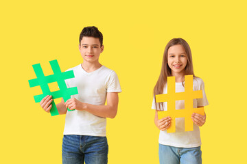 Cute teenage kids with hashtags on yellow background