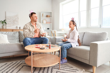 Father and his daughter having tea party at home