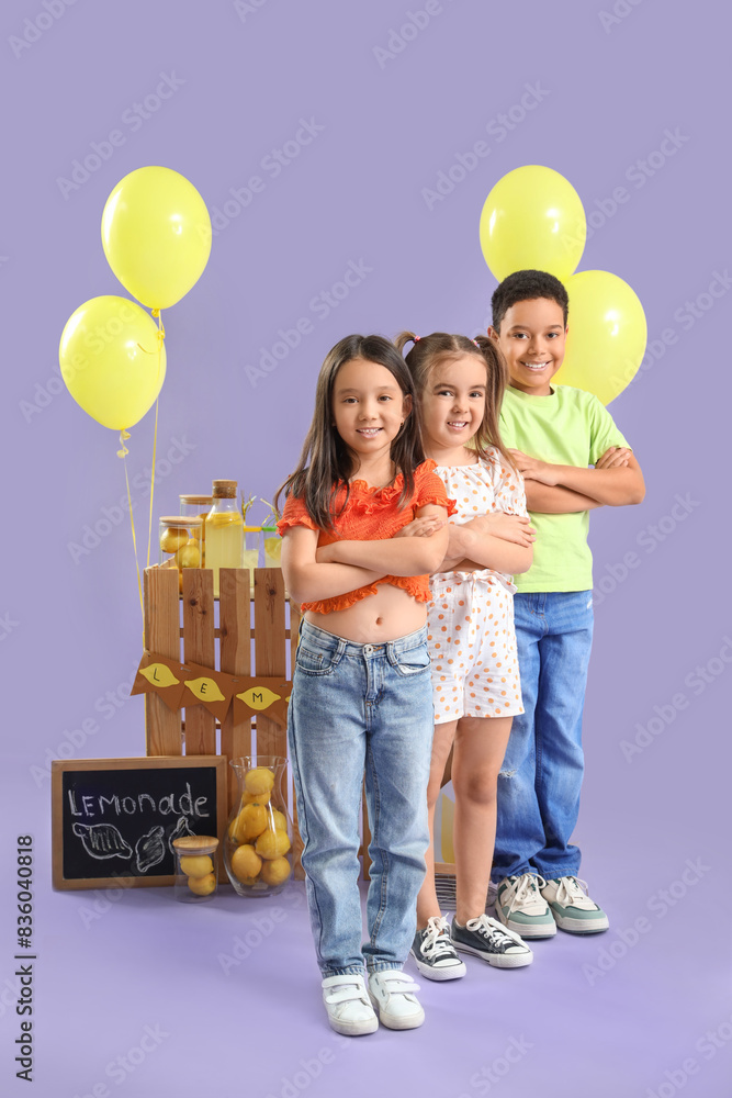 Wall mural cute little children near lemonade stand on lilac background