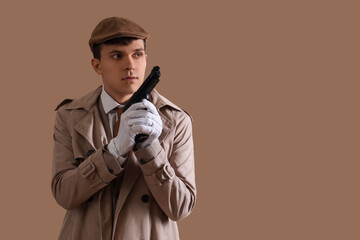 Male spy with gun on brown background