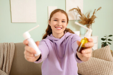 Happy young woman with medical sprays at home