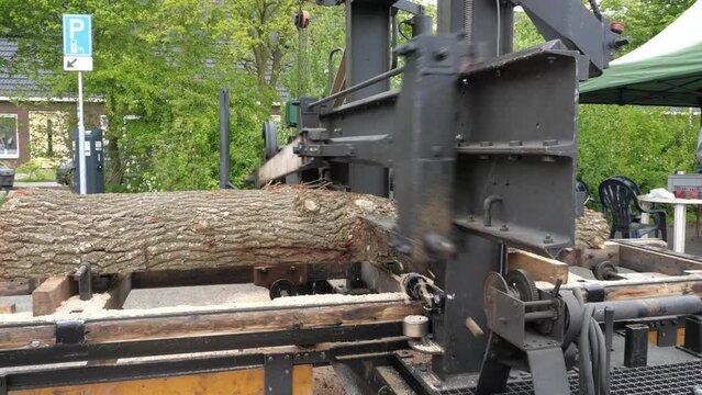 Antique Diesel-Powered Sawing Machine Cutting a Log into Slices, Close-Up
