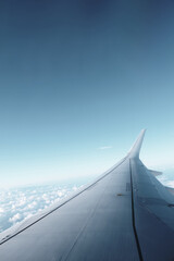 Airplane Wing View Over Clouds and Clear Sky