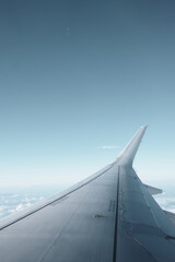 View of Airplane Wing in Clear Sky During Flight