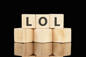 Words Laughing Out Loud. LOL word is made up of wooden cubes on a black background