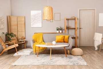 Interior of cozy living room with grey sofa, table and armchairs