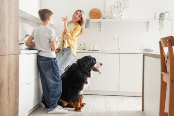 Little boy and his mother with Bernese mountain dog in kitchen