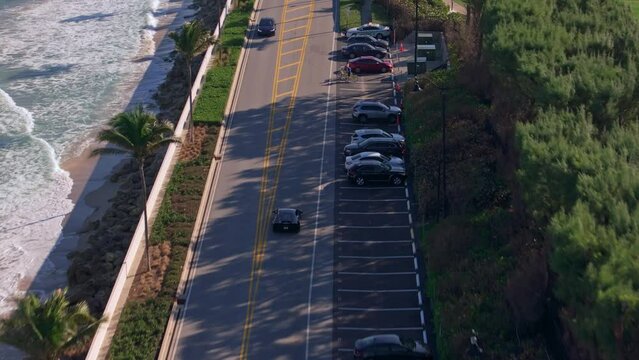 Establishing aerial rolling shot of supercar driving in Miami West Palm Beach on a sunny day. Epic drone footage of supercar driving on Miami Sunny Streets