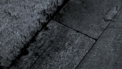 Obraz premium Black or dark gray rough grainy stone texture background with geometric line feature, copy space